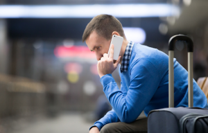 Homem no celular em aeroporto